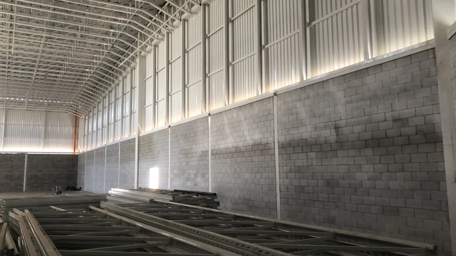 Estrutura de cobertura e fechamento lateral em obra comercial