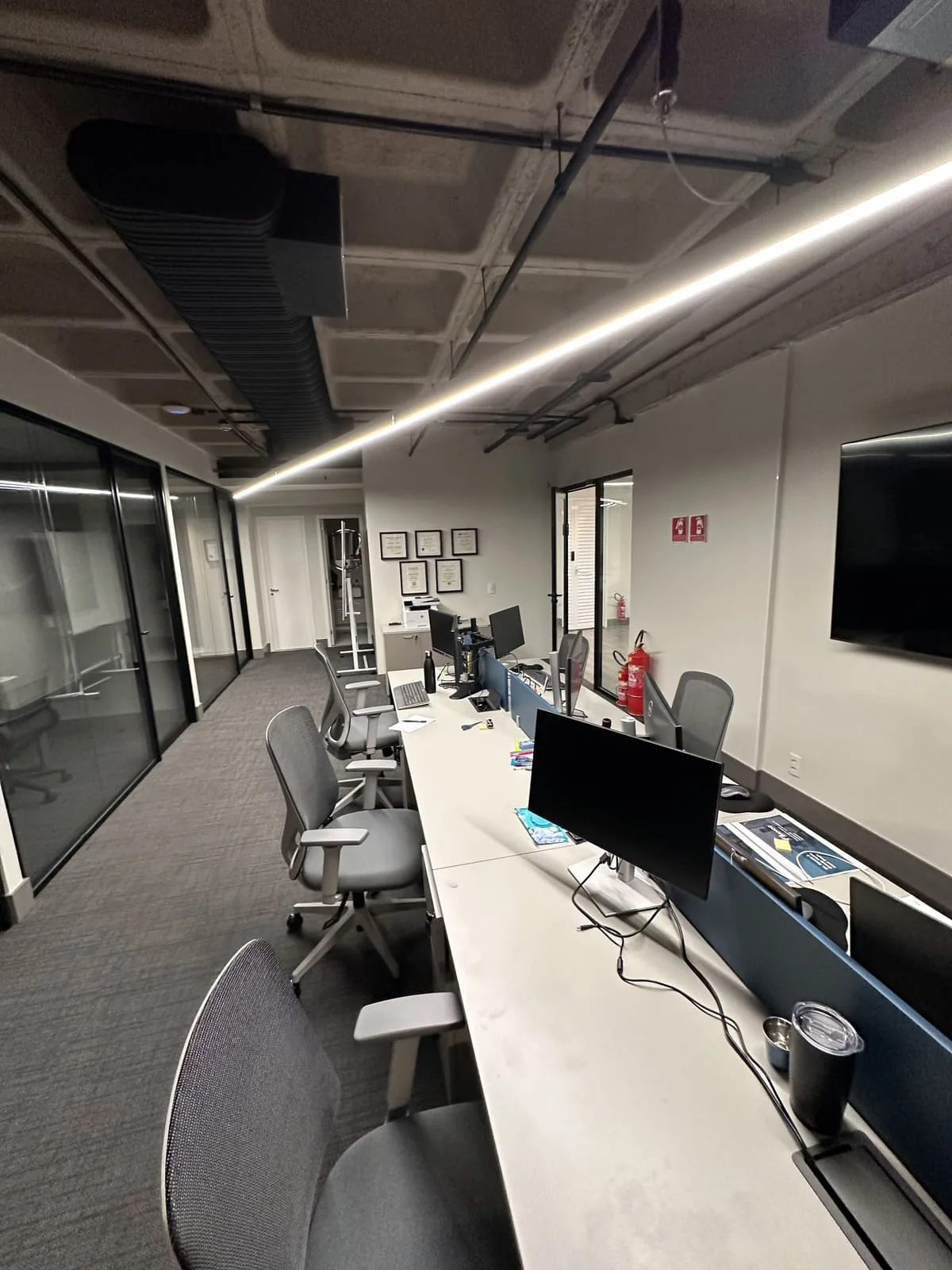 Escritório corporativo entregue, estações de trabalho e iluminação linear
